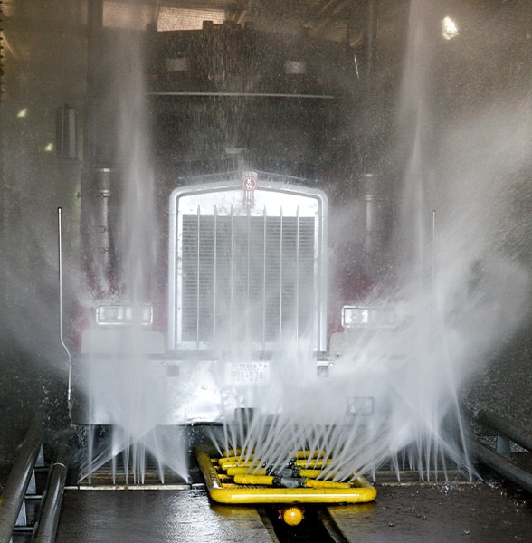 Semi going through wheel tire chassis wash system