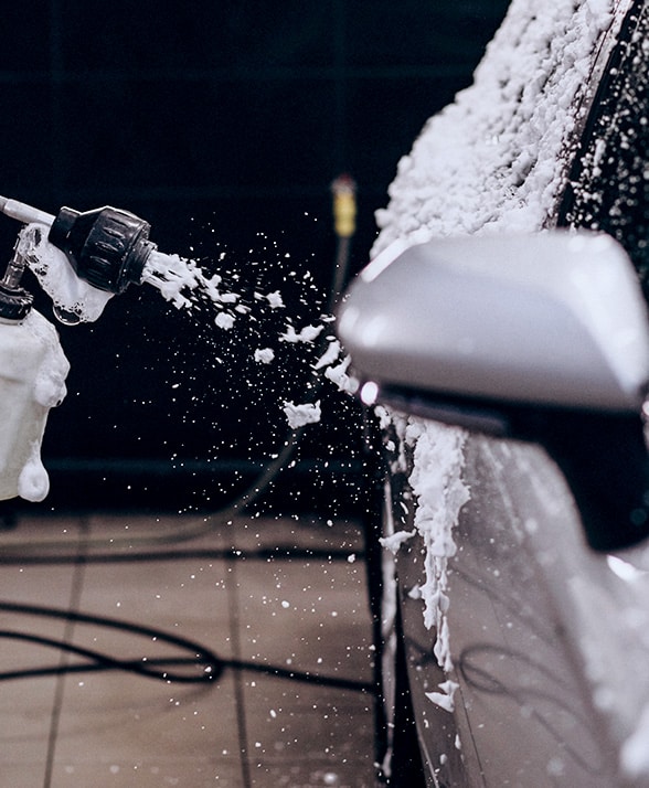 Car getting a wash from a hose