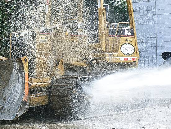 Wheel wash system cleaning a bulldozer