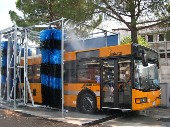 Transit bus being washed by brush system