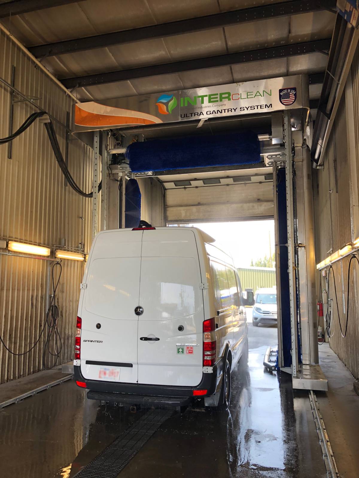 White van being cleaned by ultra gantry wash system