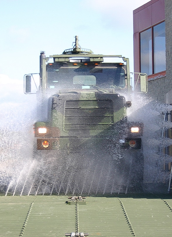 A military vehicle going through a wash system.