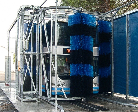 Tour bus being washed by brush system