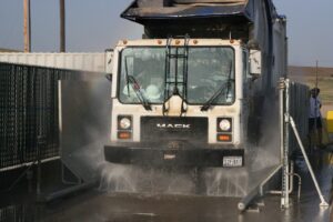 Municipal dump truck wheels and chassis being washed