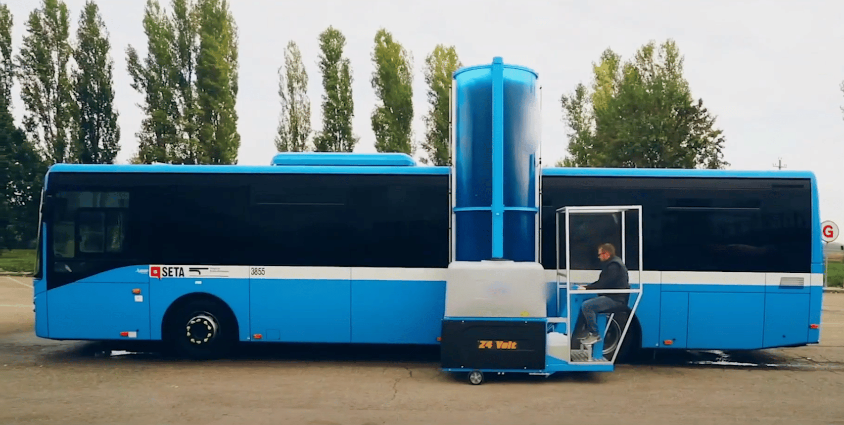 Someone washing a bus with a single brush automatic wash system