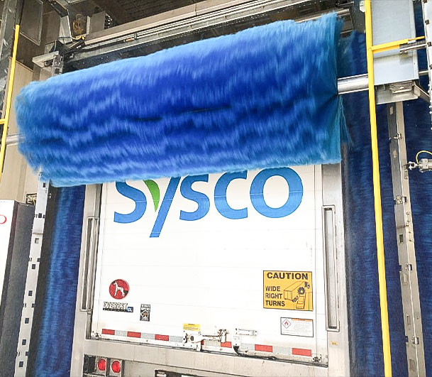 Sysco truck trailer being washed by brush system