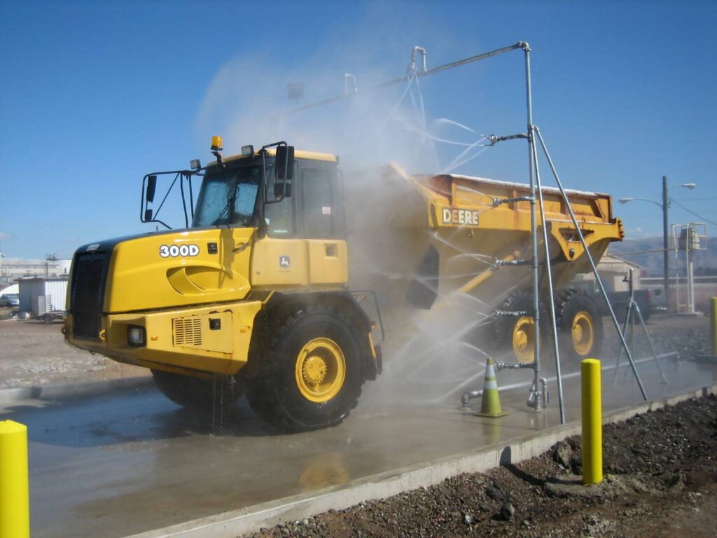 A yellow mining truck being washed by an Interclean wash system.