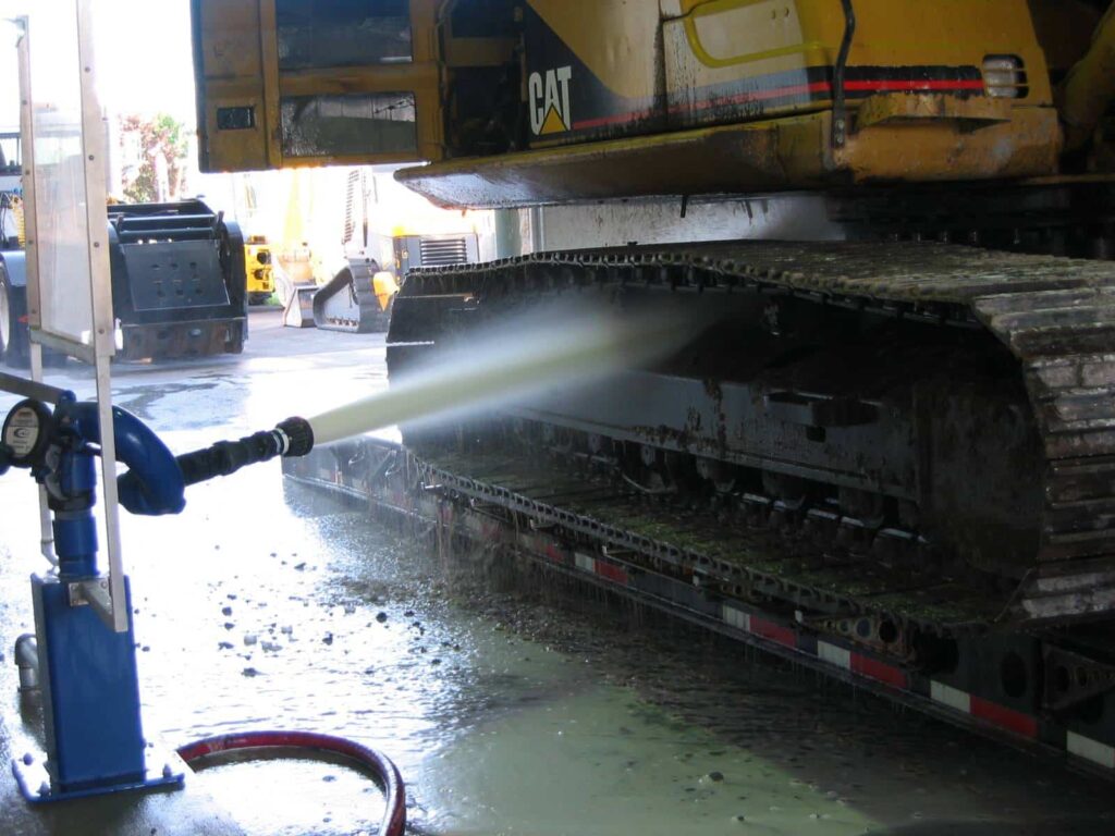 A robotic wash system spraying a mining vehicle to remove dirt.