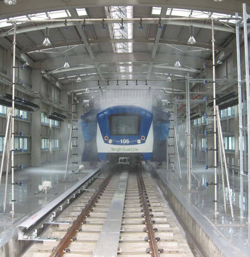 A blue and white train being washed by an InterClean train wash system.