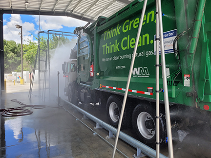Garbage truck going through a touchless spinner wash system.
